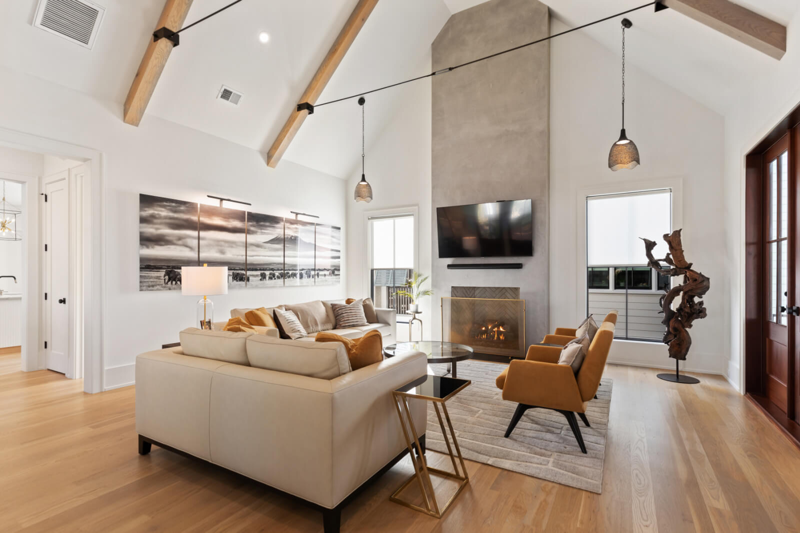White living room with high ceilings and goldenrod chairs.